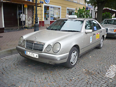 Srebrny Mercedes przed kamienicą - taksówka ŁST